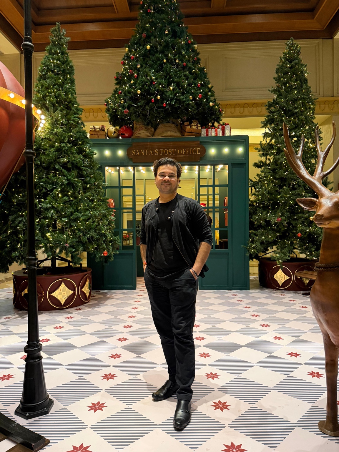 Suyash Pachauri in a black jacket, standing in a festive interior